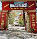 Dimçayı Rüzgar Vadisi Restoran & Piknik alanında, çayın serin suları üzerine kurulu kamelyalar, doğa ile iç içe masalar ve yeşillikler içinde piknik yapan misafirler görüntülenmiş