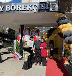 Alanya Saray Börekçisi’nin tezgâhında yer alan kat kat açılmış, peynirli ve kıymalı sıcak börek çeşitleri, arka planda çay servisiyle birlikte görüntülenmiş