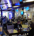 Alanya The Gossip Bar & Restaurant’ın deniz manzaralı terasında, renkli kokteyller ve lezzetli yemeklerle dolu keyifli bir akşam atmosferi.