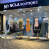 NCLA Boutique mağazasında modern ve şık kadın giyim koleksiyonu, zarif vitrin tasarımıyla sergileniyor.