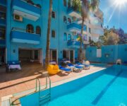 Barhan Hotel Alanya’nın açık yüzme havuzu ve balkonlu odalarla çevrili modern bina görünümü.