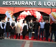 Alanya’da Ömeroğlu Lounge Cafe Bar’ın deniz manzaralı terasında kahve keyfi yapan insanlar ve şık atmosfer.