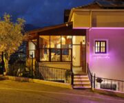 Casa Vagabundo Boutique Hotel'in Kleopatra Plajı’na yakın taş cepheli dış görüntüsü ve begonvillerle süslenmiş terası.