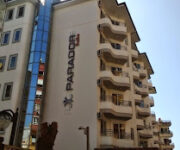 Parador Suite Apart Hotel’in açık yüzme havuzu, balkonlu apart odaları ve yeşil peyzajıyla çevrili alanlarıyla birlikte gündüz saatlerinde görüntülenmiş