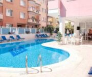 Bella Rose Apart Hotel’in açık yüzme havuzu ve balkonlu apart daireleriyle çevrili havuz manzarası.