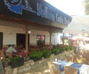 Yelken Restoran Alanya’da deniz manzaralı masada servis edilen deniz ürünleri tabağı; ızgara kalamar, karides, levrek dilimi, yeşillik ve limon dilimleriyle Akdeniz mutfağı sunumu