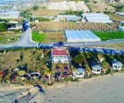 Bello Beach Alanya’da denize sıfır şezlonglar, plaj şemsiyeleri ve palmiyelerle çevrili sahil manzarası