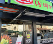 OSES Çiğköfte Gazipaşa Alanya şubesinde nar ekşili, yeşillikli ve limon eşliğinde servis edilen etsiz çiğköfte dürüm