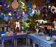 a group of people sitting at a tableNazar Café Alanya’nın deniz manzaralı açık alanında çay ve kahve keyfi yapan misafirler.