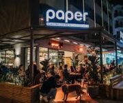 Paper Roasting Coffee & Chocolate Alanya’da latte art ile sunulan kahve ve yanında el yapımı çikolatalar eşliğinde modern, sade masa sunumu