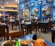 Deniz kenarında taze balık servis edilen masada Yeğen Balık Evi Alanya’nın lezzetli deniz ürünleri ve mezeleri.