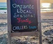 Chillers Beach Bar & Coastal Kitchen'da Akdeniz'e karşı konumlanmış sahil manzaralı masa, tropikal kokteyller ve şık yaz dekorasyonu eşliğinde gün batımı keyfi sunuyor.