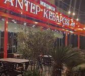 Meşhur Antep Kebapçısı Gazipaşa Alanya'da servis edilen bol közlenmiş sebzelerle süslenmiş Adana kebabı, lavaş ve meze çeşitleriyle birlikte bir masada sunuluyor. Alanya