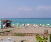 Sefa Beach Alanya’da denize sıfır şezlonglar, palmiye ağaçları ve berrak Akdeniz manzarası.