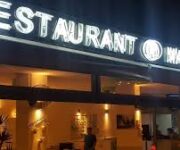 Alanya’da akşam saatlerinde ışıklarla aydınlatılmış Master Bar and Restaurant’ın modern dekorlu açık hava oturma alanı ve şık servis masaları