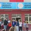 Dereköy İlkokulu ve Ortaokulu binası ve önünde toplanan öğrenciler.