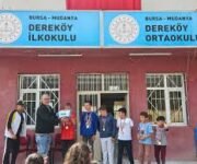 Dereköy İlkokulu ve Ortaokulu binası ve önünde toplanan öğrenciler.