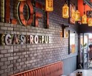 Gastro Pub’da loş ışıklar altında ahşap bir barda servis edilen özel bira çeşitleri ve gurme burger tabağı, arka planda şık ve modern dekorasyon ile birlikte görüntülenmiş