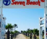 Seven Beach’in altın renkli kumsalında yer alan şezlonglar, berrak deniz ve palmiye ağaçları eşliğinde yaz güneşi altında dinlenen misafirler