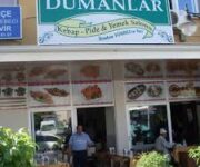 Dumanlar Kebap & Pide’de masalarda servis edilen kebap çeşitleri, pideler ve sıcak restoran ortamı.