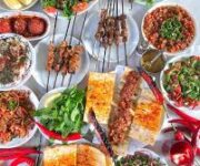 Izgara üzerinde pişen Adana kebap ve ciğer şişleri, yanında közlenmiş sebzeler