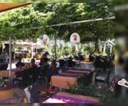 Adanus Restaurant Cafe Bar’da deniz manzarası eşliğinde Akdeniz mutfağının tadını çıkaran misafirler.