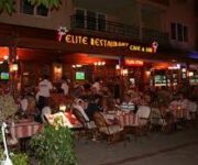 Elit Restoran’da şık bir masada sunulan özenle hazırlanmış Akdeniz mutfağı tabakları, loş ambiyans ve zarif masa düzeniyle birlikte görüntülenmiş