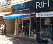 "İmece Müzik Aletleri mağazasında çeşitli enstrümanlar sergilenmiş, müşteriler ve öğrenciler ürünleri inceleyip çalıyor, modern ve düzenli bir müzik mağazası ortamı."