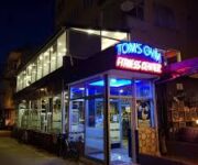 “Tom's Gym Fitness Center’da sporcular ağırlık ve kardiyo ekipmanlarıyla antrenman yapıyor”