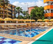 “Yaman Life Hotel’in açık yüzme havuzu ve balkonlu, modern dizaynlı odalarının dış cepheden görünümü.”