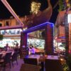 Melani Restaurant Alanya’da kaya dekorlu açık alanda ızgara et, makarna tabakları, nargile ve akşam yemeği sofrası.