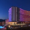 Diamond Resort SPA Hotel Alanya’nın palmiyelerle çevrili havuzu ve modern mimariye sahip otel binası.