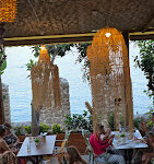 Tersane Cafe’nin tarihi Alanya Tersanesi manzaralı açık oturma alanı, denize karşı servis edilen kahve ve tatlılarla birlikte gün batımında görüntülenmiş