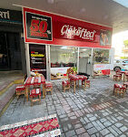 Çiğköfteci Mahmut Usta’da bol yeşillikli, limon dilimli ve nar ekşili Adıyaman usulü çiğ köfte dürüm servisi; yanında ayran ile birlikte masada sunulmuş