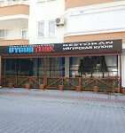 Uygur Türk Restoran’da geleneksel motiflerle dekore edilmiş bir masada servis edilen el yapımı Uygur mantısı ve etli lagman yemeği, sıcak ve otantik ortamda görüntülenmiş