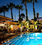 Cook's Club Alanya’nın modern havuz alanı, şık şezlongları ve tropik detaylarla dekore edilmiş sosyal alanlarıyla gün batımında görüntülenmiş