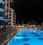 Grand Uysal Beach & Spa Hotel’in denize sıfır konumlu büyük açık havuzu, otel binası ve Akdeniz manzarasıyla birlikte güneşli bir yaz gününde çekilmiş görseli