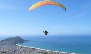 Alanya sahilinde yamaç paraşütü yapan sporcular ve deniz manzarası.
