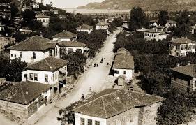 “Arkeolojik kazı alanında ortaya çıkarılan antik taş duvar ve yanında çalışan arkeologlar.”