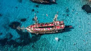 Pirate-themed boat sailing along Alanya’s coast with guests enjoying the sea and early booking offers for 2026