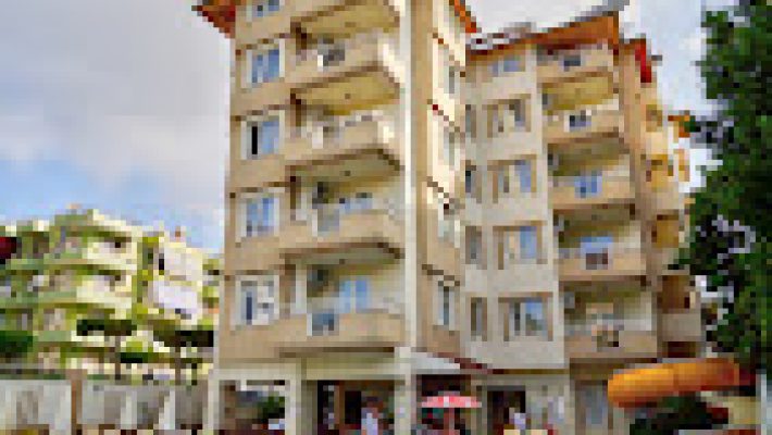 Sunway Apart Otel’in açık yüzme havuzu, balkonlu apart daireleri ve güneşli bir günde palmiyelerle çevrili dinlenme alanı görüntülenmiş