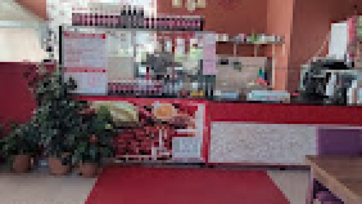 Fast Food Yavuz Pınar’da servis edilen bol yeşillikli Adıyaman usulü çiğ köfte dürüm; yanında limon, nar ekşisi ve ayranla birlikte masada görüntülenmiş