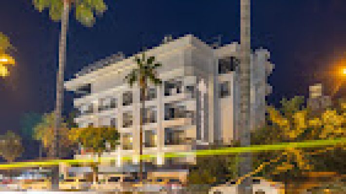 De'manor'in modern mimarili dış cephesi, giriş alanı ve çevresindeki yeşil peyzaj düzenlemesiyle birlikte gündüz vakti görüntülenmiş