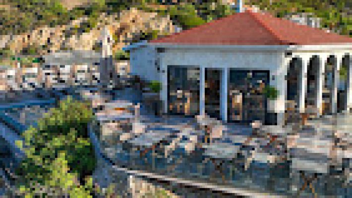 Ada Port Hotel'in havuz başında gün batımı manzarasıyla çekilmiş şık ve modern otel binası