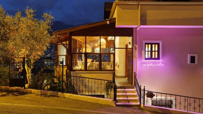 Casa Vagabundo Boutique Hotel'in Kleopatra Plajı’na yakın taş cepheli dış görüntüsü ve begonvillerle süslenmiş terası.