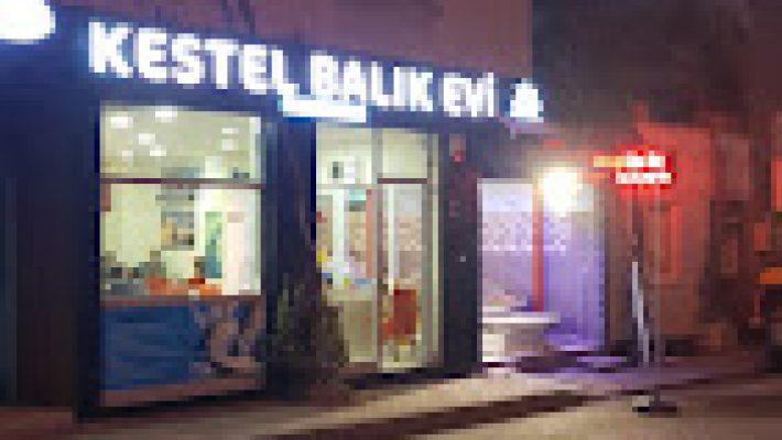 Kestel Balık Evi'nin deniz manzaralı açık alanında taze ızgara balık, meze tabakları ve limon dilimleriyle servis edilen şık bir masa