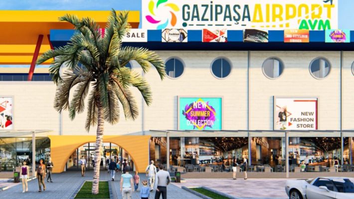 Gazipaşa Airport AVM giriş cephesi; modern mimari, geniş yürüyüş alanı, mağaza vitrinleri ve havalimanı ulaşım noktalarına yakın alışveriş merkezi görünümü Alanya