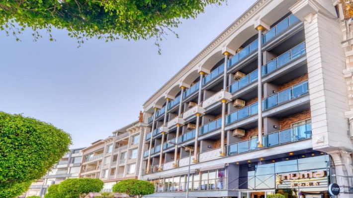 “Numa Port Hotel’in Alanya limanına bakan dış cephesi, modern cam balkonlar ve deniz manzaralı odalar.”
