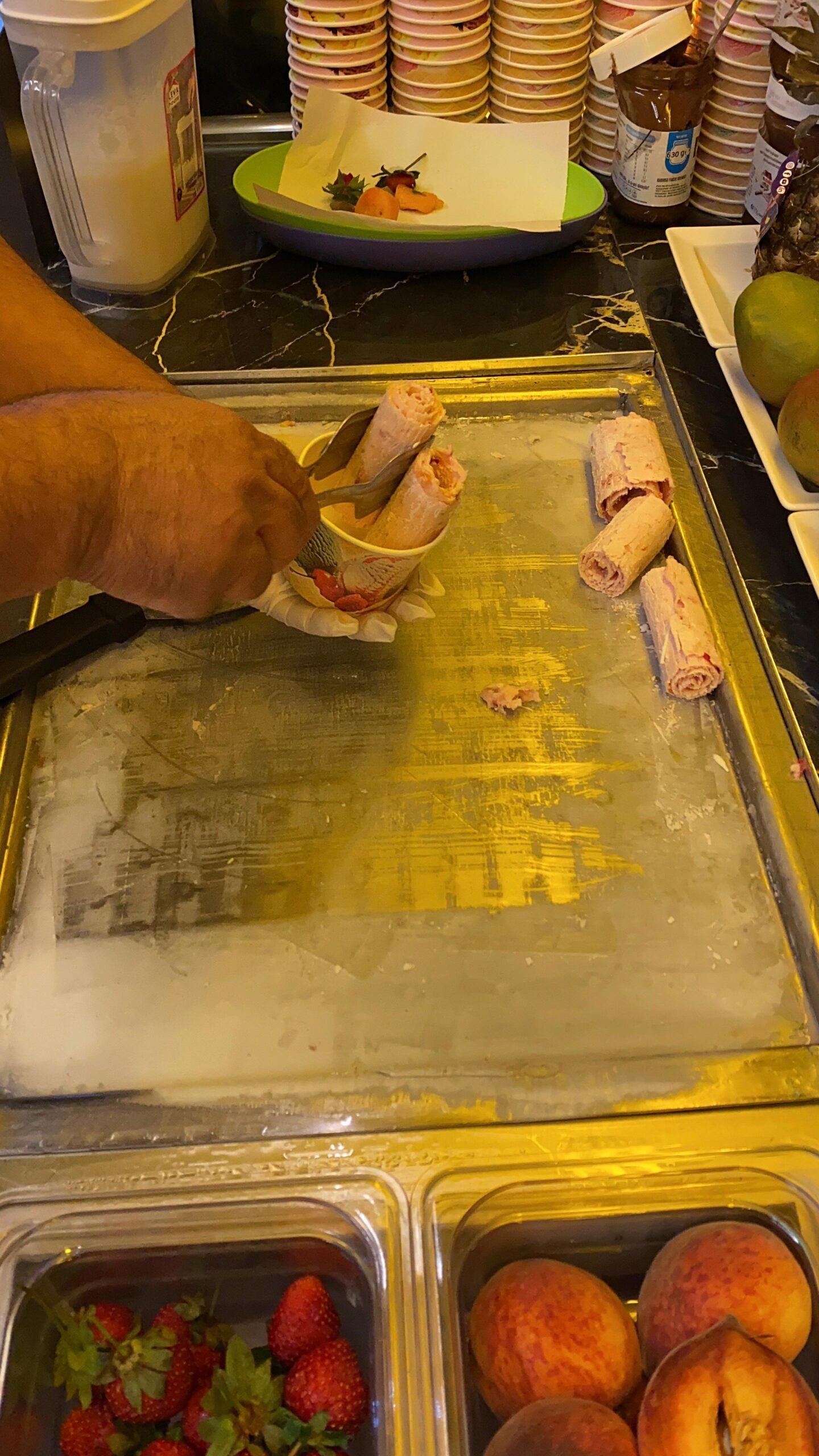 The Brother’s Coffee’s Alanya’da tava dondurma ustasının rulo dondurma hazırlarken yaptığı şov, etrafında fotoğraf çeken tatilciler