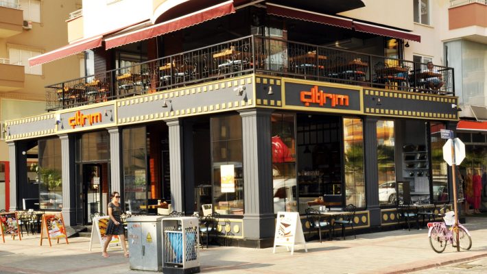 Çıtırım Pastanesi Alanya’da vitrine dizilmiş taze yaş pastalar, kurabiyeler ve kahve eşliğinde masa sunumu